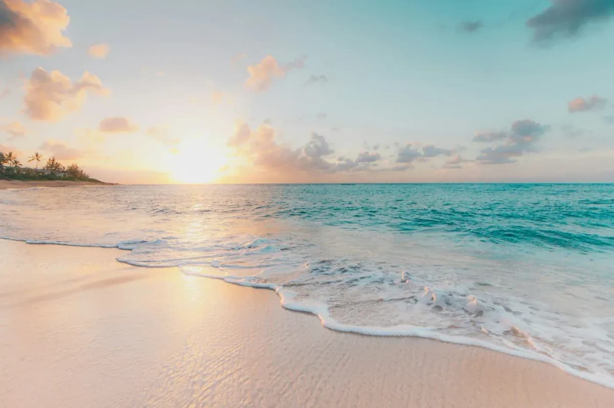 Turquoise water and white sand beach at sunset
